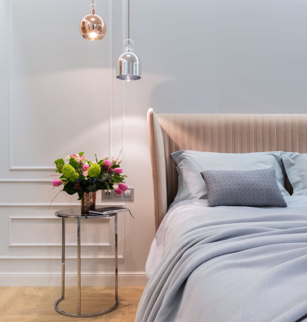 apartment-interior-with-bed-near-table-with-flowers-in-vase